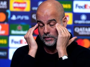 Pep Guardiola puts his hands to his head during a press conference