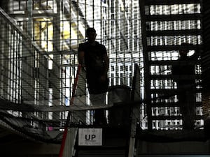 Silhouette of two people near stairs inside a prison