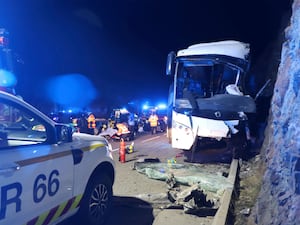 The wrecked bus, in the blue light of police cars