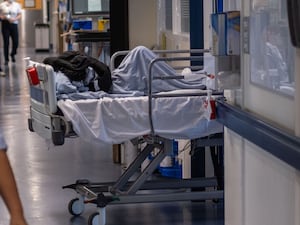 A patient on a bed in a hospital corridor