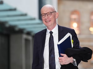 Pat McFadden carrying a file and smiling