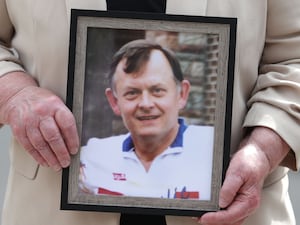 Hands holding a picture of murdered GAA official Sean Brown