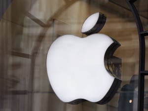 The Apple logo in the window of an Apple store