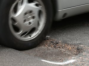 A car hits a pothole on a road i