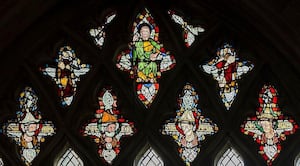 Erkenwald depicted in a window at Wells Cathedral; the heads depict