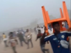 A man holds a chair during the chaos