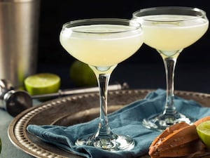 A pair of lime and gin cocktails in fancy glasses