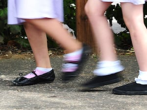 An image of girls walking in school shoes