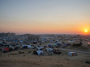 The sun sets over a tent camp for displaced Palestinians in the central Gaza Strip town of Khan Younis