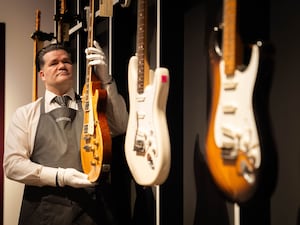 An art handler holds a 1959 Gibson Les Paul known as Yardburst during the photocall for the Jeff Beck: The Guitar Collection at Christie’s in central London