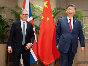 Sir Keir Starmer and Xi Jinping in front of their nations' flags