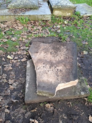 The damaged gravestone.