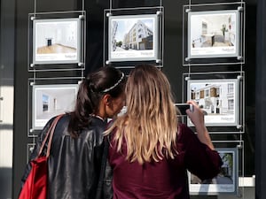 People looking in an estate agent's window