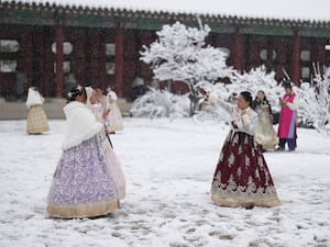 People in traditional costume outside a palace