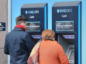 People withdrawing cash at a Barclays ATM machine