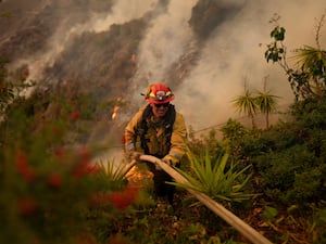 A firefighter battles the Palisades Fire in Mandeville Canyon