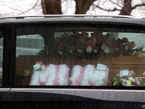 A floral tribute which says 'Mum' alongside the coffin in the hearse for Karen Cummings' funeral