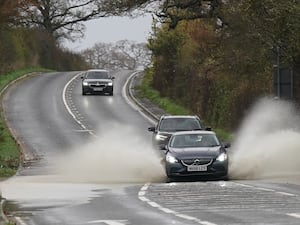 A vehicle is driven through floodwater after heavy rain in Shipston-on-Sour in Warwickshire