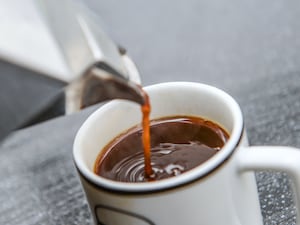 A cup of coffee being poured