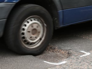 A car hits a pothole on a road in Islington, London