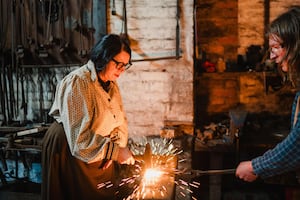 A participant trying blacksmithing during a Blacksmith Experience Day at Blists Hill Victorian Town