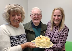 Hannah Morris and Julia Clarke present Terry with a birthday cake.
