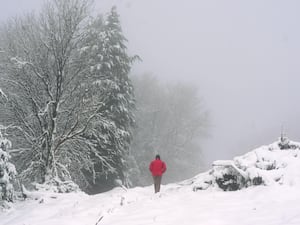 A man walks through a snowy pass