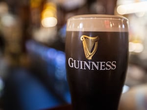 A pint of Guinness sits on a bar