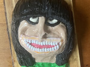 Image of a caricature-style cake of Claudia Winkleman complete with Tic Tacs for teeth and black icing for her famous hairstyle