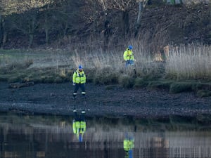 Workers in hi-viz next to a river