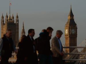 Commuters walk in London with Big Ben in the background