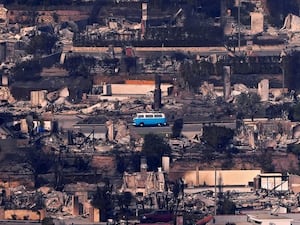 A VW van sits among burned-out homes in Malibu, California