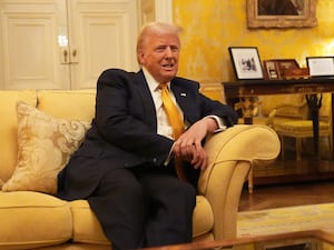 Donald Trump sitting on a yellow sofa in the Salon Jaune at the UK Ambassador's residence in Paris