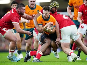 Australia’s Nic White is tackled by Wales’ Dewi Lake and Christ Tshiunza