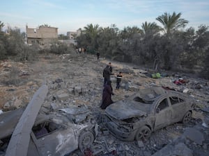 Palestinians inspect the site of an Israeli strike in Deir Al-Balah in the central Gaza Strip