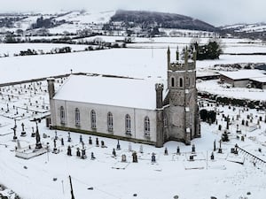 People make their way through snow to Mass at Holy Cross Catholic Church in Killeshin