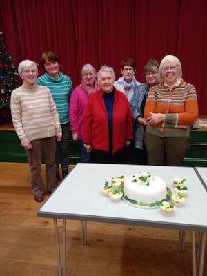 Members of Merched y Bont with Velma Hutchinson and the decorated cake