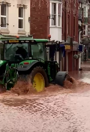 A man in a tractor driving down Tenbury Wells 