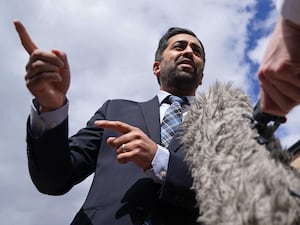 Humza Yousaf pointing while speaking intro a microphone