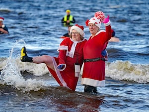 Two people in the sea in Santa outfits