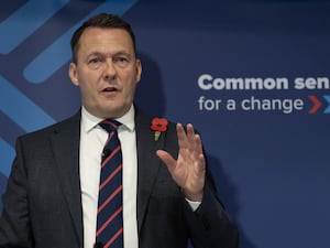 Russell Findlay with one hand raised while speaking