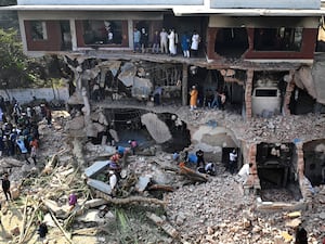 People watch as others take away the metal and electric wirings from a vandalised property