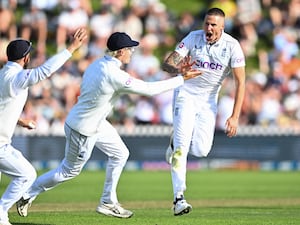 England’s Brydon Carse celebrates with teammates after taking the wicket of New Zealand’s Daryl Mitchell