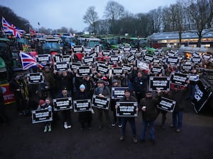 Farmers holding placards in front of their tractors at Belmont Farm in north London