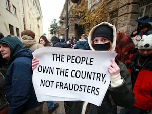 A protester holds a poster during a rally near the Parliament building in Tbilisi to demand new elections in Georgia