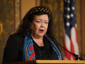 Dame Karen Pierce speaking, with an American flag behind her