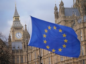 The European Union flag flying in front of the Houses of Parliament in London