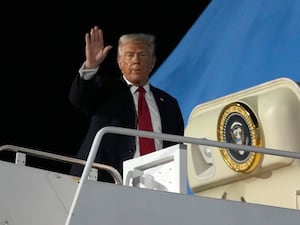 Donald Trump waving at the entrance of Air Force One