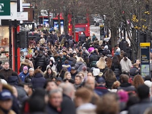 A crowd of shoppers walking along a street