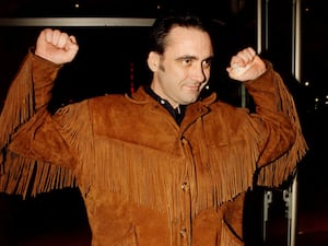 Tony Slattery with arms raised, pictured in 1998 wearing a brown suede jacket